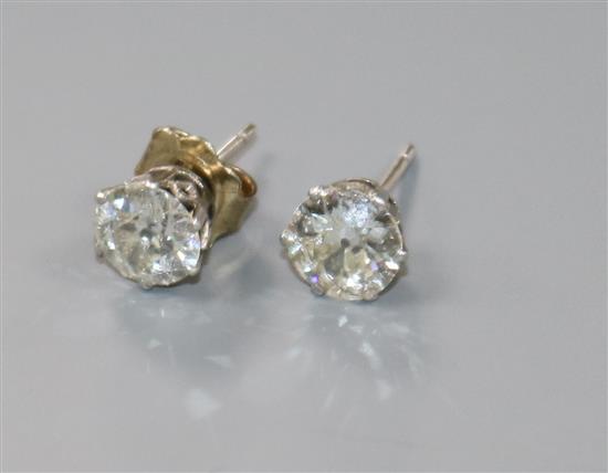 A pair of white metal and solitaire diamond ear studs,